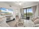 Living room featuring neutral tones, balcony access, and tile flooring at 17510 Gawthrop Dr # 208, Bradenton, FL 34211