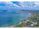 Stunning aerial view of waterfront homes and coastline, with downtown in the distance under a cloudy blue sky at 1773 South Dr, Sarasota, FL 34239