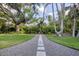 Landscaped backyard featuring a stone pathway with a bench surrounded by lush greenery at 1773 South Dr, Sarasota, FL 34239