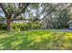 Beautifully landscaped yard with mature trees provides ample shade at 1773 South Dr, Sarasota, FL 34239