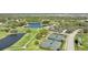Aerial view showcasing the community's tennis courts, lush golf course, and tranquil pond surrounded by homes at 2111 Muskogee Trl, Nokomis, FL 34275