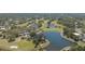 Scenic aerial view of community clubhouse, shimmering lake, golf course, and lush landscaping at 2111 Muskogee Trl, Nokomis, FL 34275