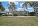 Back of the home with a screened-in lanai pool with nice landscaping at 2111 Muskogee Trl, Nokomis, FL 34275