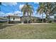 A view of the screened-in lanai pool and the yard from the lawn at 2111 Muskogee Trl, Nokomis, FL 34275