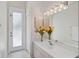 Bathroom features a white vanity, ample lighting and a doorway to the exterior at 2111 Muskogee Trl, Nokomis, FL 34275
