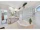 Bright bathroom featuring tub, walk-in shower, and dual sinks at 2111 Muskogee Trl, Nokomis, FL 34275