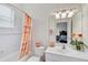 Bathroom with a shower-tub combo, white vanity and floral decoration at 2111 Muskogee Trl, Nokomis, FL 34275