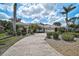 Beautiful one-story home showcasing meticulous landscaping, mature palms, and a circular brick paved driveway at 2111 Muskogee Trl, Nokomis, FL 34275