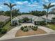 Beautiful home showcasing mature palm trees, lush landscaping, a circular driveway, and a tile roof at 2111 Muskogee Trl, Nokomis, FL 34275