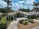 Beautiful home featuring a circular driveway surrounded by lush landscaping and mature palm trees at 2111 Muskogee Trl, Nokomis, FL 34275