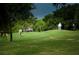 Picturesque golf course view with manicured greens and mature trees, showcasing a golfer putting on the green at 2111 Muskogee Trl, Nokomis, FL 34275