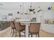 Open concept kitchen with an island, white cabinets, and bar seating at 2111 Muskogee Trl, Nokomis, FL 34275
