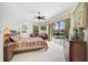 Comfortable main bedroom featuring pool view, ceiling fan, and carpet flooring at 2111 Muskogee Trl, Nokomis, FL 34275
