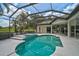 The screened-in pool features a spa and offers a great view of the green landscape at 2111 Muskogee Trl, Nokomis, FL 34275