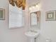 Clean powder room with a pedestal sink, mirror, and framed art at 2111 Muskogee Trl, Nokomis, FL 34275