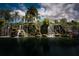 Stunning waterfall feature surrounded by tropical plants and palm trees, creating a tranquil and luxurious ambiance at 2111 Muskogee Trl, Nokomis, FL 34275