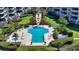 Aerial view of a community pool, bordered by lush gardens, seating, and perfectly manicured green grass at 2185 Gulf Of Mexico Dr # 243, Longboat Key, FL 34228