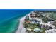 Stunning aerial view of beachfront condos, turquoise water, a sandy beach, and lush landscaping at 2185 Gulf Of Mexico Dr # 243, Longboat Key, FL 34228