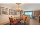 Elegant dining room with a glass-top table, chandelier, and views of the living room and ocean at 2185 Gulf Of Mexico Dr # 243, Longboat Key, FL 34228