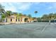 A spacious tennis court with lush green surroundings and a beautifully designed clubhouse in the background at 2185 Gulf Of Mexico Dr # 243, Longboat Key, FL 34228