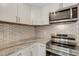 Close up of kitchen featuring stainless steel appliances, white cabinetry, and decorative tile backsplash at 2319 Beneva Ter # 2284, Sarasota, FL 34232