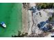 Breathtaking aerial view of a pristine white sand beach with turquoise waters and a boat along the shoreline at 244 Cedar Park Cir, Sarasota, FL 34242