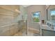 Well-lit bathroom with a glass enclosed shower, stone accent wall, and granite countertops at 244 Cedar Park Cir, Sarasota, FL 34242