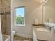 Bright bathroom with a shower-tub combo, decorative tile accent and a sink with a stone countertop at 244 Cedar Park Cir, Sarasota, FL 34242
