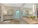 Luxurious bathroom featuring dual vanities, a standalone tub, and a window with a water view at 244 Cedar Park Cir, Sarasota, FL 34242