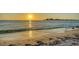 Peaceful beach scene with golden sand, gentle waves, and a radiant sunset reflecting on the water at 244 Cedar Park Cir, Sarasota, FL 34242