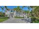 Stately two-story home with a brick driveway, mature landscaping, and a welcoming entrance with stairs at 244 Cedar Park Cir, Sarasota, FL 34242