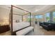 Bedroom featuring a four-poster bed, sitting area, and access to an outdoor balcony at 244 Cedar Park Cir, Sarasota, FL 34242