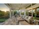 Relaxing outdoor living space features plush seating, an outdoor fireplace, and views of the landscaped backyard and surrounding greenery at 244 Cedar Park Cir, Sarasota, FL 34242