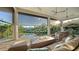 Inviting outdoor living area with comfortable seating, fire feature, and views of the pool and waterway beyond the screened enclosure at 244 Cedar Park Cir, Sarasota, FL 34242