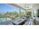 Covered patio with a built-in grill, dining area, and views of the pool and waterfront at 244 Cedar Park Cir, Sarasota, FL 34242