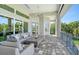 Covered patio with a fire pit, ample seating, and views of lush greenery and the waterfront at 244 Cedar Park Cir, Sarasota, FL 34242