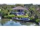 Picturesque waterfront property featuring a private dock, lush landscaping, and serene views of the water at 244 Cedar Park Cir, Sarasota, FL 34242