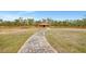 Exterior view of a barn with a winding stone pathway in a vast green field at 24705 83Rd E Ave, Myakka City, FL 34251