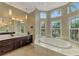 Bright bathroom with a corner tub with natural light, double vanity sinks, and ample counter space at 24705 83Rd E Ave, Myakka City, FL 34251