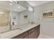 Modern bathroom featuring double sinks, granite countertops, and a large mirror at 24705 83Rd E Ave, Myakka City, FL 34251