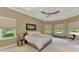 Relaxing bedroom retreat featuring a tray ceiling, neutral tones, and natural light from multiple windows at 24705 83Rd E Ave, Myakka City, FL 34251