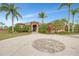 Beautiful single-story home featuring a circular driveway with stone inlay and lush landscaping at 24705 83Rd E Ave, Myakka City, FL 34251
