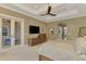 Comfortable main bedroom featuring neutral tones, a tray ceiling, and patio access at 24705 83Rd E Ave, Myakka City, FL 34251
