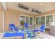 Covered patio with stone flooring, ceiling fan, heaters, and inviting blue outdoor seating at 24705 83Rd E Ave, Myakka City, FL 34251