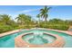 Inviting backyard spa, perfect for relaxation and entertaining, surrounded by green plants and a clear blue sky at 24705 83Rd E Ave, Myakka City, FL 34251