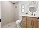 Modern bathroom showcasing a walk-in shower, updated vanity, and decorative, round mirror at 2720 Pinewood Ct, Clearwater, FL 33761