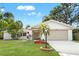 Charming single-story home with a well-manicured lawn, mature trees, and a two-car garage at 2720 Pinewood Ct, Clearwater, FL 33761