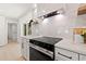 Modern kitchen with marble backsplash, stainless steel appliances, and sleek white cabinets at 2720 Pinewood Ct, Clearwater, FL 33761