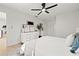 Bright main bedroom featuring a ceiling fan, neutral decor, and a stylish dresser with artwork at 2720 Pinewood Ct, Clearwater, FL 33761