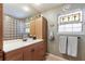 Updated bathroom with glass block shower, single sink vanity and built in linen cabinet at 2723 59Th St, Sarasota, FL 34243
